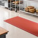 A red heavy-duty rubber anti-fatigue floor mat with a diamond pattern and straight edges, designed for grease resistance.