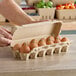 A person holding a Choice Pulp egg carton full of eggs.