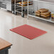 A red heavy-duty rubber anti-fatigue floor mat with a diamond pattern and straight edges, designed for grease resistance.