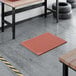 A heavy-duty red rubber anti-fatigue floor mat with a diamond pattern and straight edges, designed to be grease-resistant.