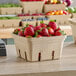 A Choice produce basket filled with strawberries on a table.