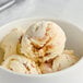 A bowl of Tillamook Caramel Swirl ice cream with a close up of a scoop of ice cream on top.