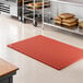 A heavy-duty red rubber anti-fatigue floor mat with a diamond pattern and straight edges, designed for grease resistance.