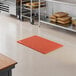A red heavy-duty rubber anti-fatigue floor mat with a diamond pattern and straight edges, designed for grease resistance.