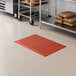 A red heavy-duty rubber anti-fatigue floor mat with a diamond pattern and beveled edge, designed for grease resistance.