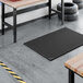 A heavy-duty black rubber anti-fatigue floor mat with a diamond pattern and straight edges, measuring approximately 3 1/4 feet by 4 15/16 feet and 7/8 inch thick.
