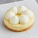 A White Toque gluten-free vanilla cheesecake tartlet with white frosting on top.