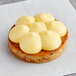 A close up of a White Toque gluten-free lemon tartlet with white frosting on top.