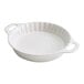 A white round baking dish with a handle.