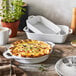 A white Staub pie dish with a pie in it on a table.