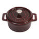 A red Staub mini Dutch oven with a lid and handle.