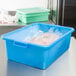 A Vollrath blue plastic container with plastic bags in it.