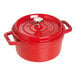 A Staub cherry red enameled cast iron Dutch oven with a lid.