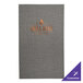 A grey H. Risch, Inc. Milan menu cover with the logo "grillhaus" on a table in a steakhouse.