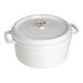 A white Staub enameled cast iron pot with a lid.