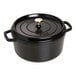 A black Staub enameled cast iron Dutch oven with a lid.