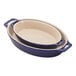 A Staub dark blue ceramic oval baking dish set with handles.