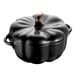 A black Staub ceramic pumpkin mini pot with a handle.
