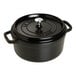 A black Staub enameled cast iron Dutch oven with a lid.