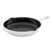 A black and white Staub enameled cast iron skillet with a handle.