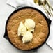 A Staub enameled cast iron skillet with a cookie and ice cream on it.