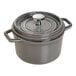 A Staub graphite gray enameled cast iron mini Dutch oven with lid and handle.