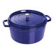 A dark blue Staub enameled cast iron Dutch oven with a lid.