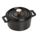 A black Staub enameled cast iron mini Dutch oven with a lid and a handle.