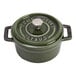 A green Staub enameled cast iron mini Dutch oven with a lid.