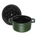 A green Staub enameled cast iron mini Dutch oven with a black lid.