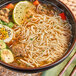 A bowl of soup with Lotus Foods Traditional Pho Rice Noodles and vegetables.
