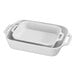 A stack of white rectangular Staub baking dishes with two handles.