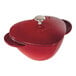 A Staub cherry red enameled cast iron pot with a lid.