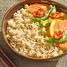 A bowl of cooked long grain brown jasmine rice served with vegetables.