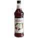 A Monin bottle of Wild Raspberry Syrup with a label.