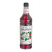 A close up of a Monin Wild Raspberry Syrup bottle full of red liquid.