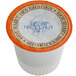 A white Caffe de Aroma single serve coffee cup with orange and blue text reading "Decaf Hazelnut" and an orange and brown lid.