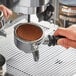 A hand using a Lavazza Espresso Italiano coffee machine to make espresso.