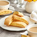 A plate of biscotti and a cup of coffee with a stack of food on it.