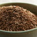 A white bowl filled with brown Regal caraway seeds.