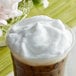 A cup of coffee with whipped cream on top.