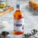 A bottle of McCormick Culinary Imitation Rum Extract on a table next to a variety of cupcakes.