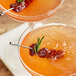 Two glasses of cocktails with wild strawberry garnish.