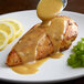 A plate of food with Regal yellow mustard sauce over a piece of meat.