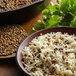 A bowl of rice with whole coriander on top.