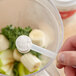 A person holding a spoon with Add A Scoop Energy Blend supplement powder in it.