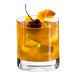A glass of Zing Zang Sweet and Sour Mix with ice and a cherry on top.