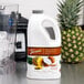 A white plastic jug of Torani Pina Colada Fruit Smoothie Mix next to a blender.