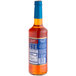 A close-up of a Torani Sugar-Free Orange Fruit Syrup bottle with a blue label.