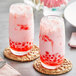 Two glasses of pink liquid with red bubbles and Fanale Guava Concentrated Syrup with pink and white straws.